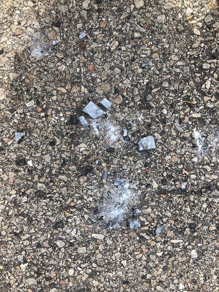 One grave marker appears to have been carried to the street and smashed